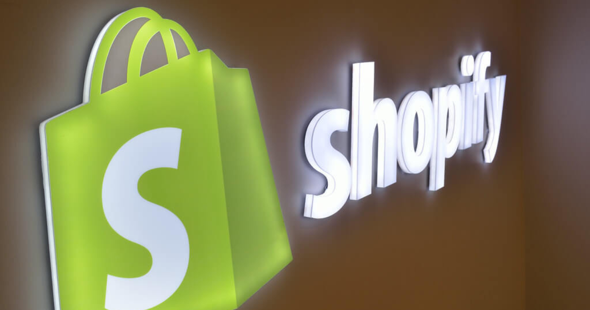 A light up Shopify logo sign on a wall