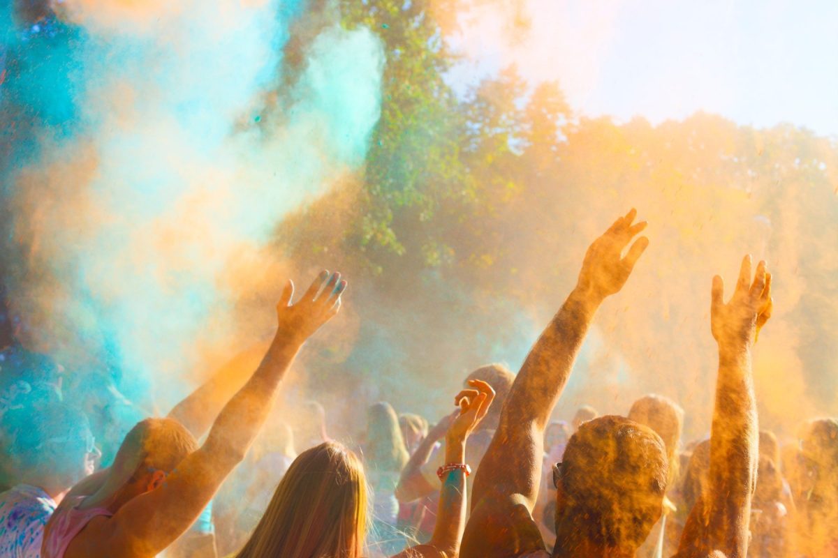 people outside celebrating with blue and orange colour powder