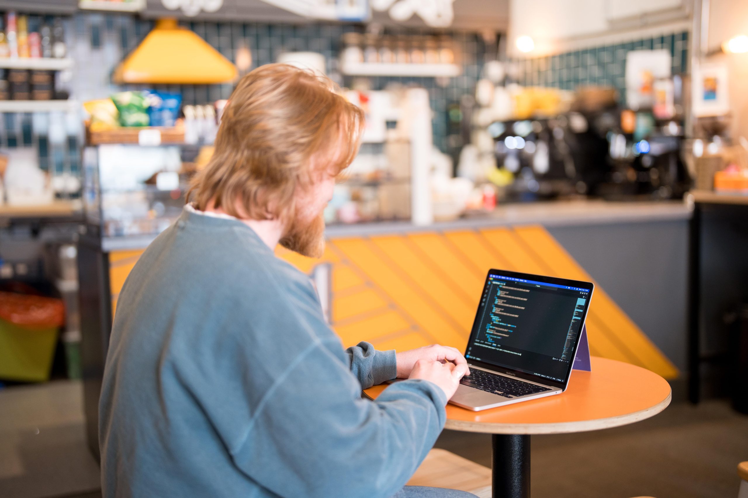 jacob from the wonder agency coding in a coffee shop on a laptop