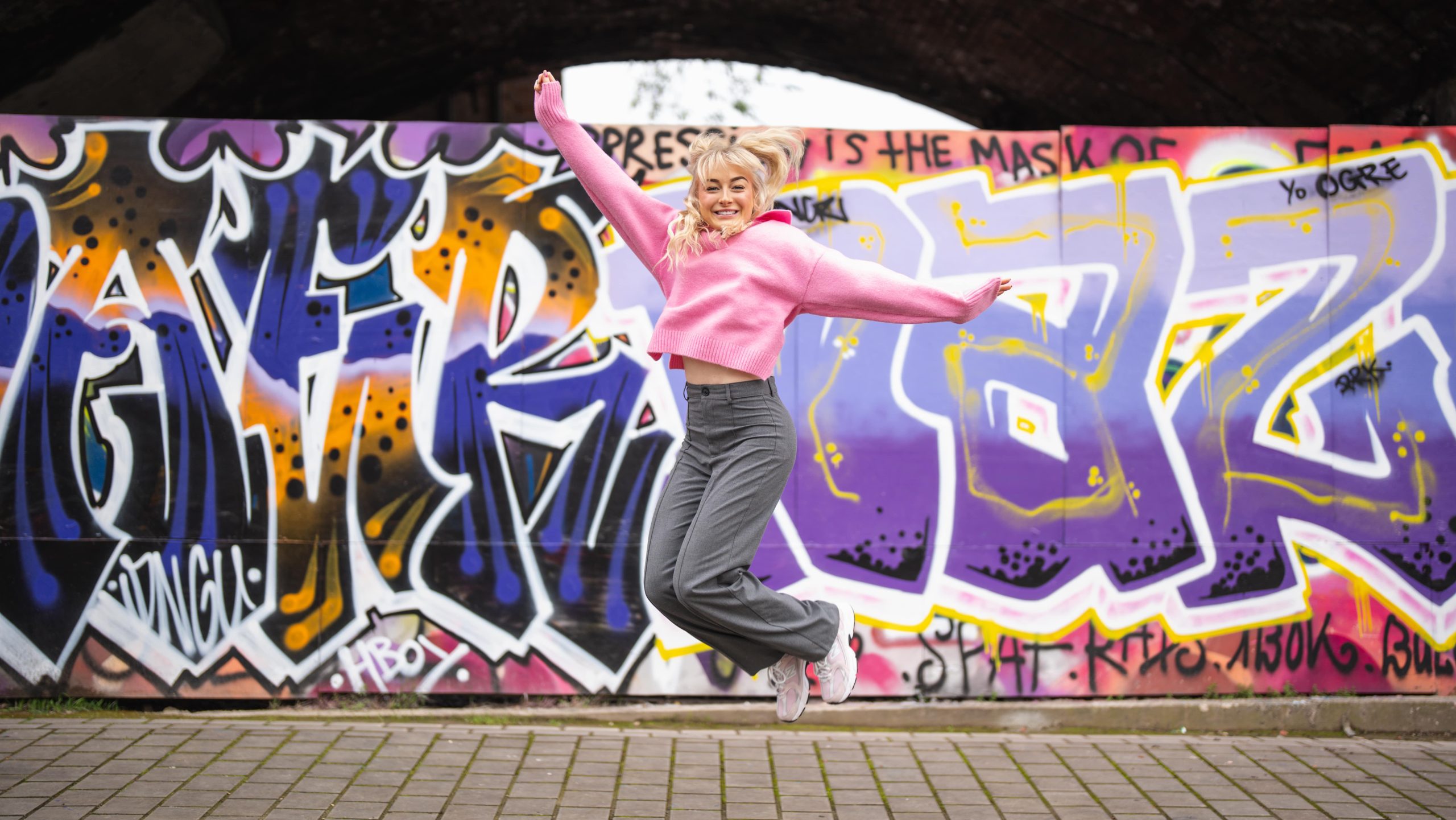 meg milner, senior account exec at the wonder agency, jumping in front of graffitied wall