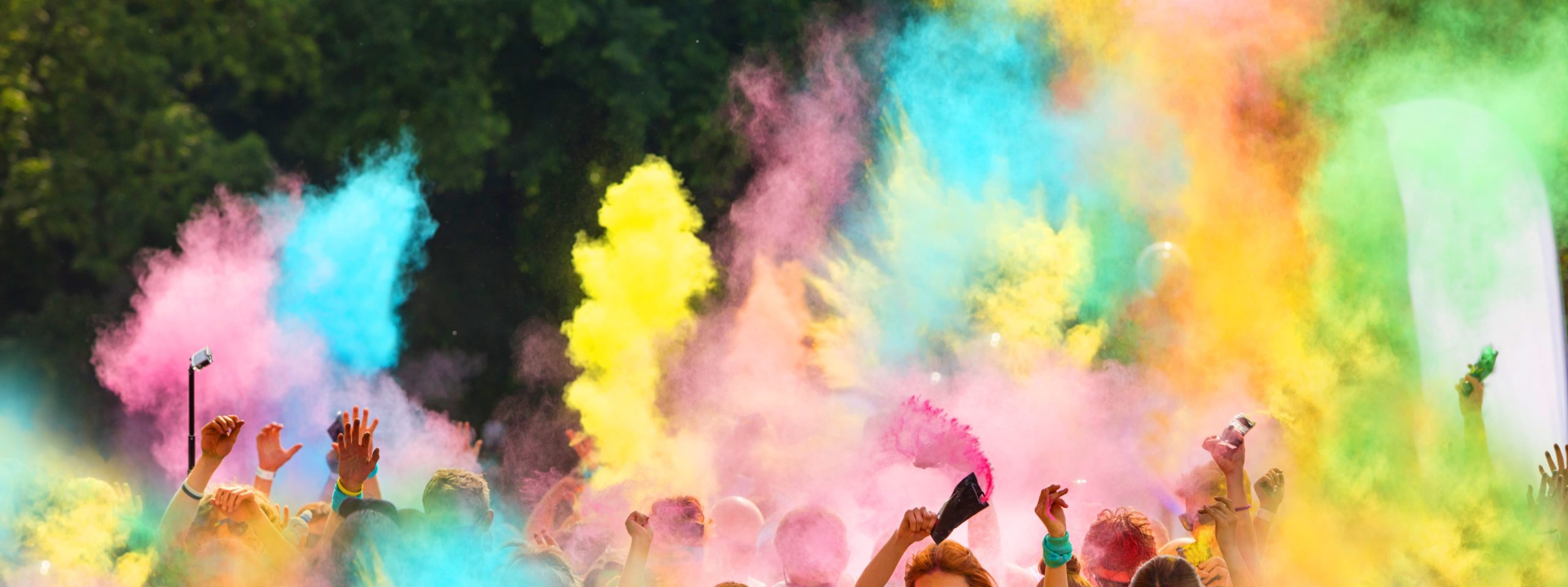 a group of people throwing colour powder in the air