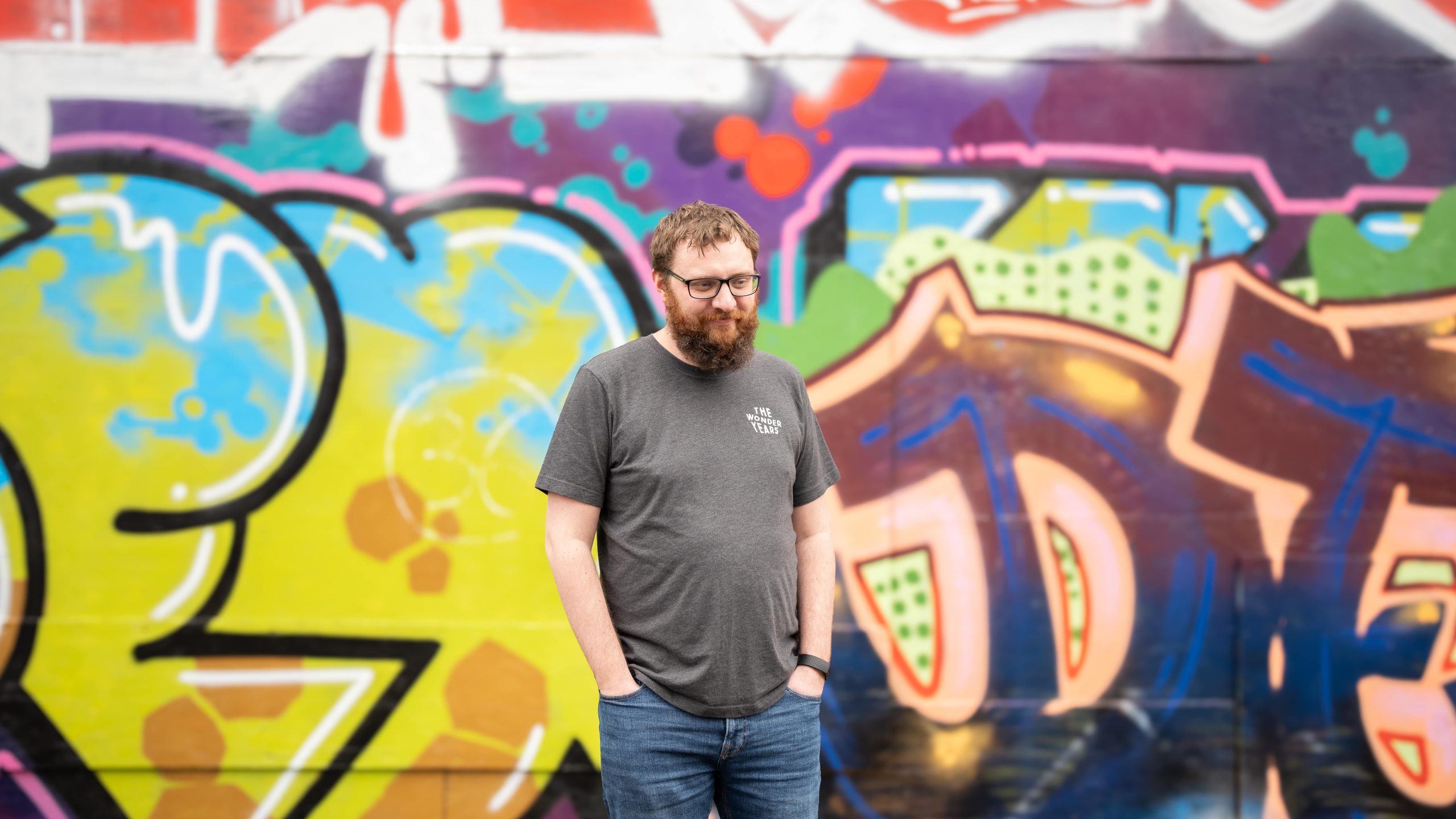 sam kirkbride, technology director at the wonder agency stood in front of graffitied wall