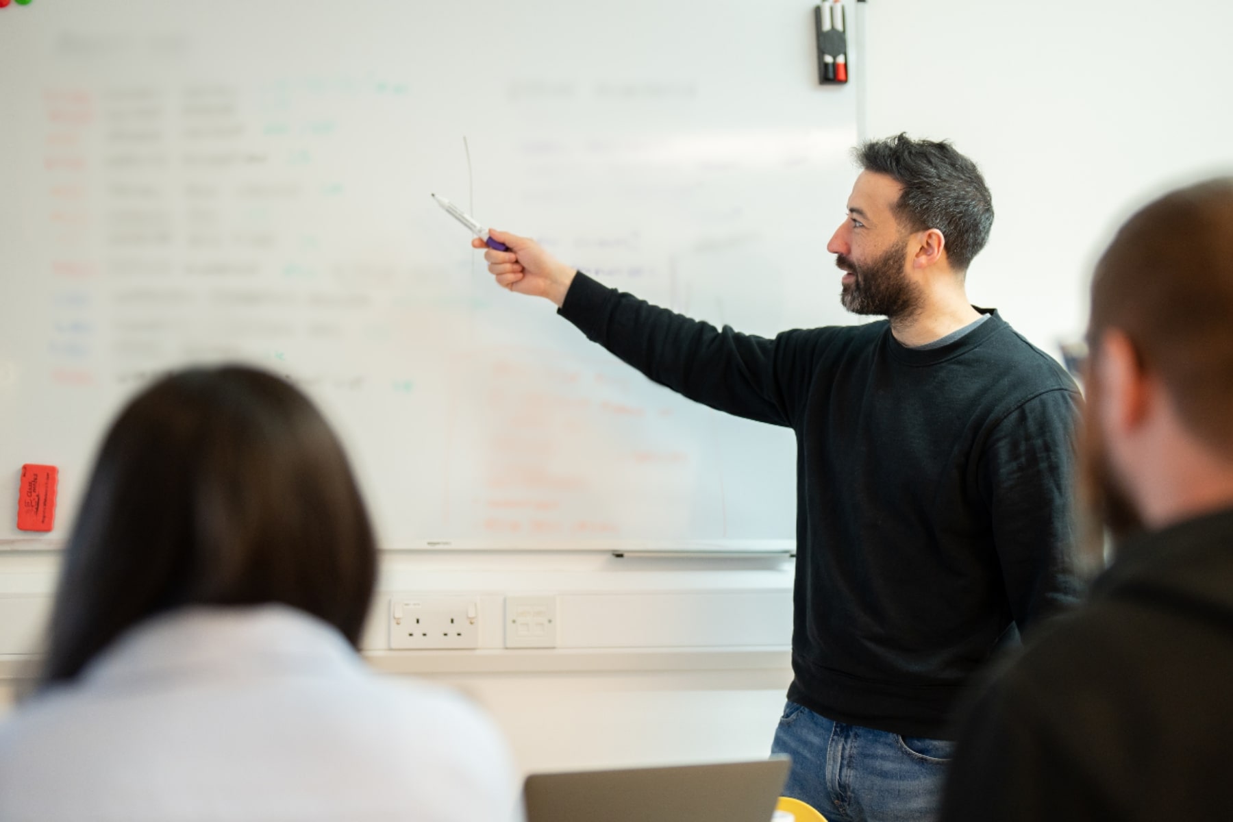 steve presenting to lauren and sam on a whiteboard at the wonder agency