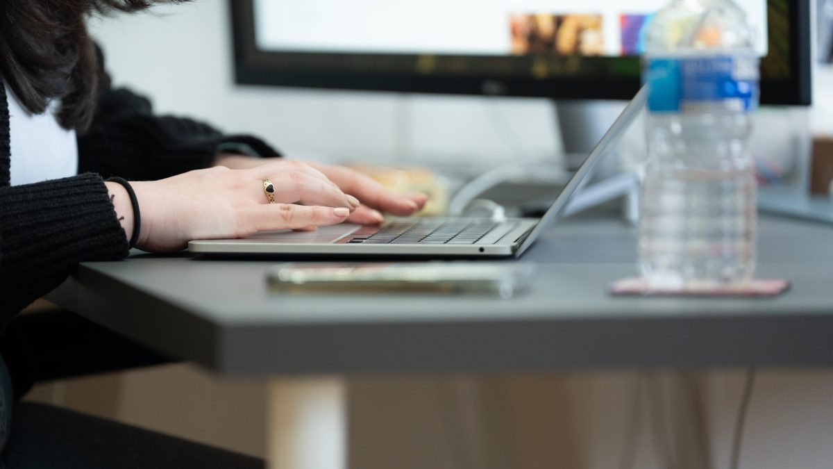 a pair of hands typing on a laptop keyboard