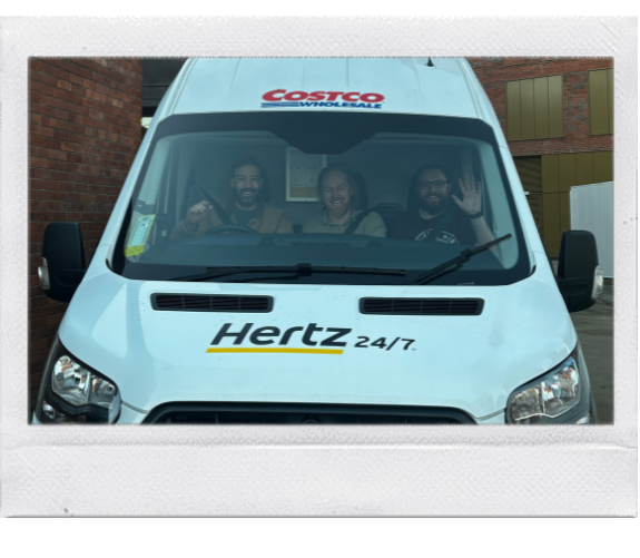 A polaroid frame showing sam, steve and jacob from the wonder agency in the front seats of a van