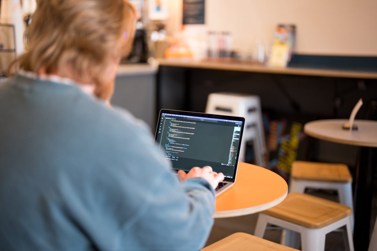 jacob from the wonder agency coding on a laptop in a cafe