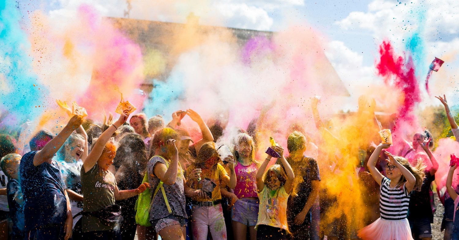 Children throwing colour powder in the air outside, featured on a case study on Wonder Agency's Shopify website build for Ministry of Colours