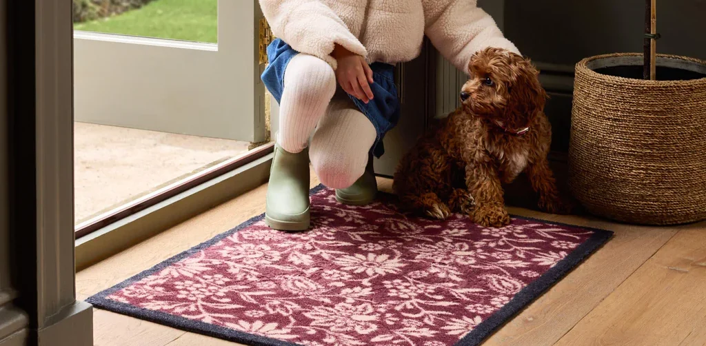 A dog and girl stood on a front door doormat, featured on a case study on Wonder Agency's custom advent calendar build for Hug Rug