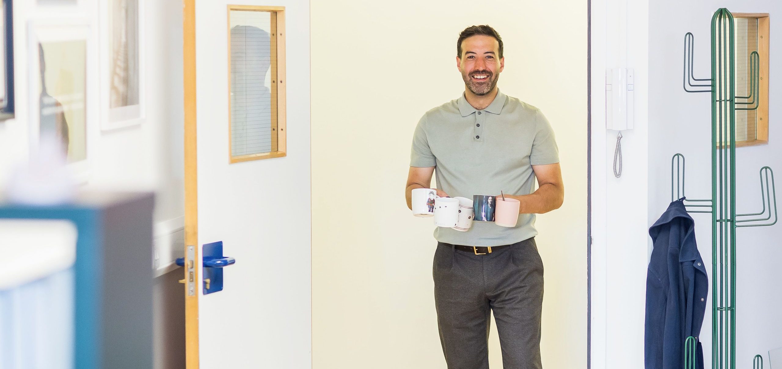 Wonder Agency team member carrying mugs during a break at the office